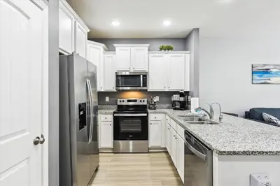 a kitchen with white cabinets and stainless steel appliances at 7664 Shadow Lake - Happy Horizons - 3 Bedroom Sleeps 9 townhouse in Panama City Beach