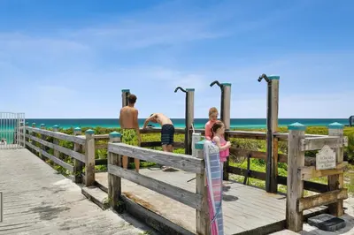 a family looking at the beach from a wooden boardwalk at 30A Villas at Sunset Beach by Panhandle Getaways in Rosemary Beach