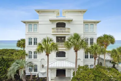 a white building with palm trees in front of it at 30A Villas at Sunset Beach by Panhandle Getaways in Rosemary Beach