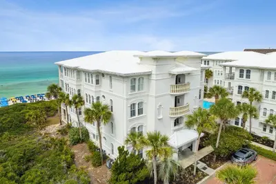 an aerial view of a white building with palm trees at 30A Villas at Sunset Beach by Panhandle Getaways in Rosemary Beach
