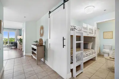 a bedroom with two bunk beds and a bathroom at Laketown Wharf #333 by Nautical Properties in Panama City Beach