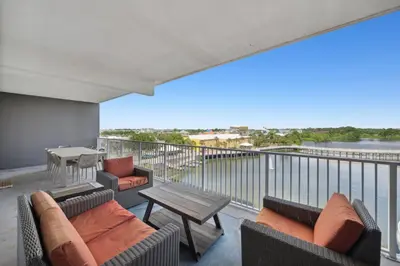 a balcony with couches and tables and a view of the water at Laketown Wharf #333 by Nautical Properties in Panama City Beach