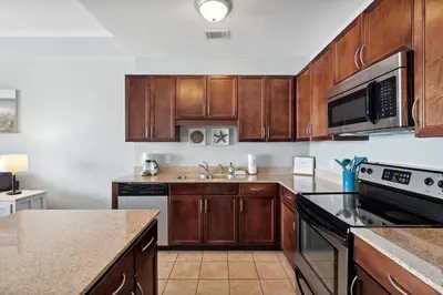 a kitchen with wooden cabinets and a counter top at Laketown Wharf #2136 by Nautical Properties in Panama City Beach