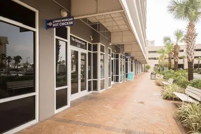 a hallway of a building with benches and palm trees at Laketown Wharf #2136 by Nautical Properties in Panama City Beach