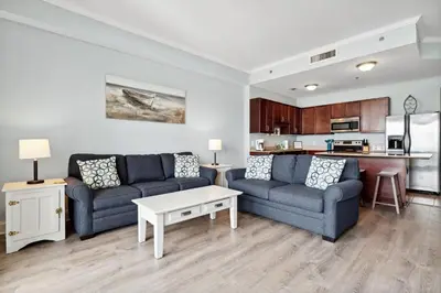 a living room with two couches and a kitchen at Laketown Wharf #2136 by Nautical Properties in Panama City Beach