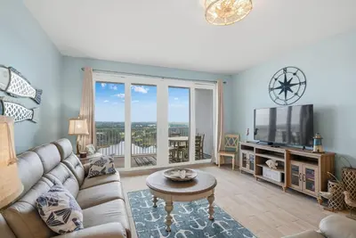 a living room with a couch and a tv at Laketown Wharf #1628 by Nautical Properties in Panama City Beach