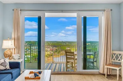 a living room with a view of a balcony at Laketown Wharf #1628 by Nautical Properties in Panama City Beach