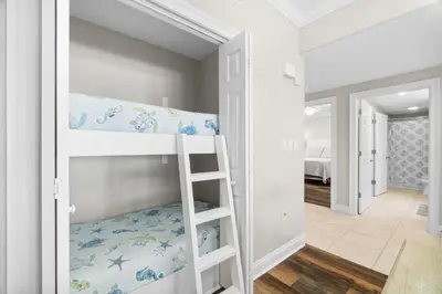 a white bunk bed in a room with a hallway at Treasure Island #1008 in Panama City Beach