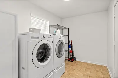 a white washing machine in a white laundry room at Stylish 3BR 2BA House Minutes from PCB - Book now in Panama City