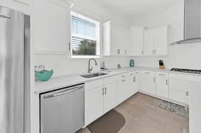 a white kitchen with white cabinets and a sink at Grande Pointe Sea Shell in Inlet Beach