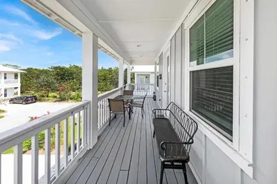 a porch with chairs and a bench on it at Grande Pointe Sea Shell in Inlet Beach