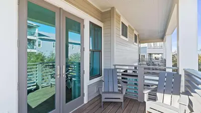 a porch with two blue chairs and a table at 30A Beach Therapy in Inlet Beach