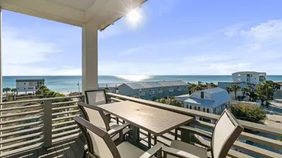 a table and chairs on a balcony with a view of the ocean at 30A Beach Therapy in Inlet Beach