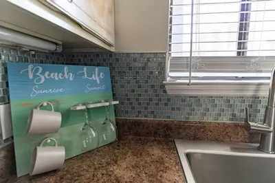 a kitchen with a sink and a sign on the wall at Spacious Family Hideaway on the Emerald Coast! in Panama City Beach