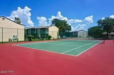 a tennis court in front of a building at Spacious Family Hideaway on the Emerald Coast! in Panama City Beach