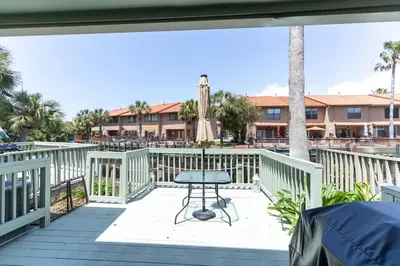 a patio with a table on a deck at Spacious Family Hideaway on the Emerald Coast! in Panama City Beach