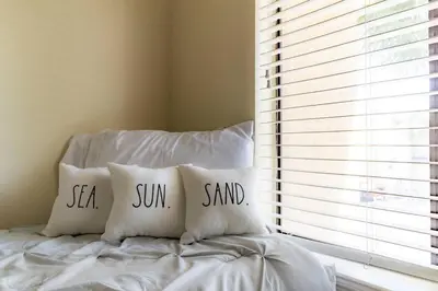 a bed with two pillows saying sea sun and sand at Spacious Family Hideaway on the Emerald Coast! in Panama City Beach
