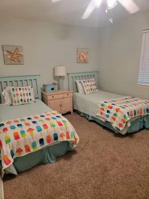 a bedroom with two beds and a table with a lamp at 188WSD in Panama City Beach