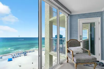 a chair on a balcony with a view of the beach at Long Beach Resort 1-904 in Panama City Beach