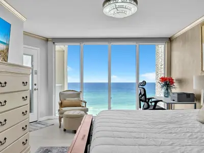 a bedroom with a bed and a view of the ocean at Long Beach Resort 1-904 in Panama City Beach