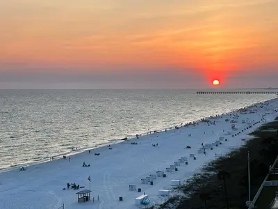 a group of people on a beach at sunset at Long Beach Resort 1-904 in Panama City Beach