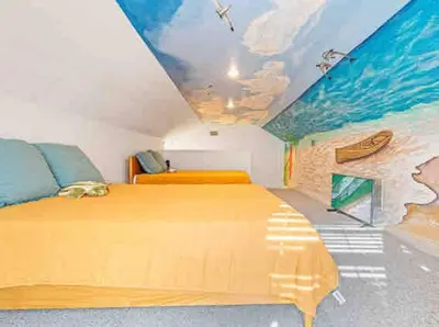 a bedroom with a bed with a painting of the ocean at Luxurious 4BR Beach House with Pool in Panama City Beach
