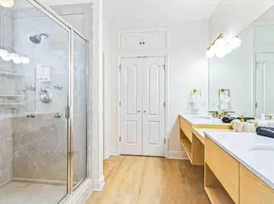 a white bathroom with two sinks and a shower at Luxurious 4BR Beach House with Pool in Panama City Beach