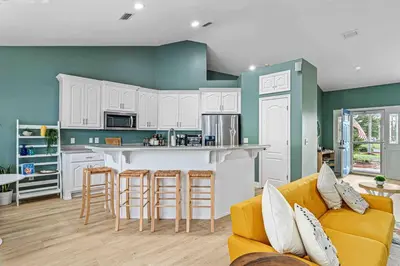 a living room with a couch and a kitchen at Luxurious 4BR Beach House with Pool in Panama City Beach