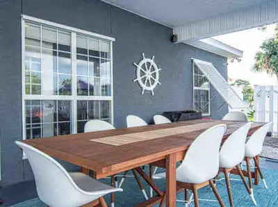a dining room with a wooden table and white chairs at Luxurious 4BR Beach House with Pool in Panama City Beach
