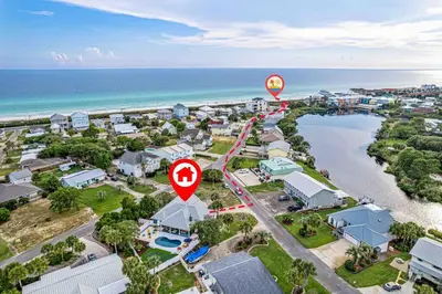 an aerial view of a town with a kite flying over the ocean at Luxurious 4BR Beach House with Pool in Panama City Beach
