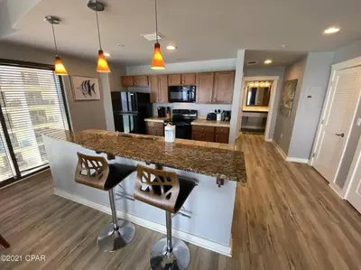 a kitchen with a counter and two bar stools at Beautiful Beach Condo - luxury living at its best in Panama City Beach