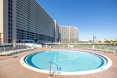 a large swimming pool with chairs and a building at Laketown Wharf #1509 by Nautical Properties in Panama City Beach
