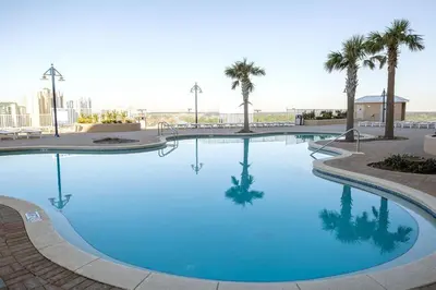 a large blue swimming pool with palm trees in the background at Laketown Wharf #1509 by Nautical Properties in Panama City Beach