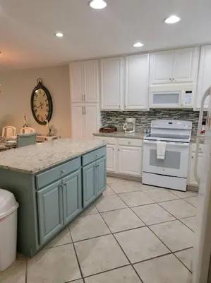 a kitchen with white cabinets and a clock on the wall at Gulf Highlands 230 WSD in Panama City Beach
