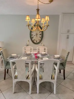 a dining room table with chairs and a clock on the wall at Gulf Highlands 230 WSD in Panama City Beach
