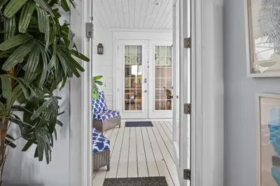 a porch with blue and white chairs and a door at Gulf Views, Large Private Pool, 30A, Two Kitchens in Seacrest