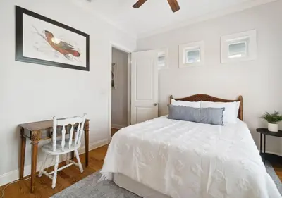 a white bedroom with a bed and a desk at Cozy Beach House (4 min walk) w/Pool + Fast WiFi in Panama City Beach