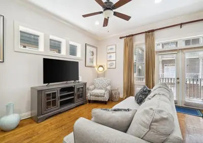 a living room with a couch and a flat screen tv at Cozy Beach House (4 min walk) w/Pool + Fast WiFi in Panama City Beach