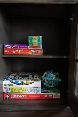 a shelf with books and other toys on it at Cozy Beach House (4 min walk) w/Pool + Fast WiFi in Panama City Beach