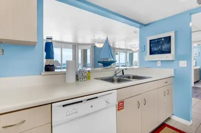 a kitchen with a sink and a blue wall at Long Beach Resort 3-404 in Panama City Beach