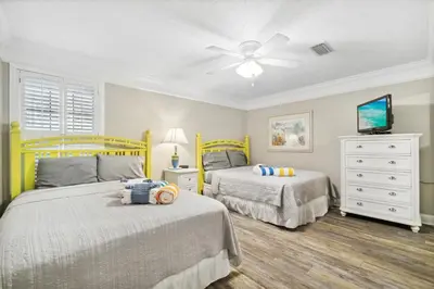 a bedroom with two beds and a ceiling fan at Seaspray Hideaway Sleeps 8 Pools Beach Access in Panama City Beach