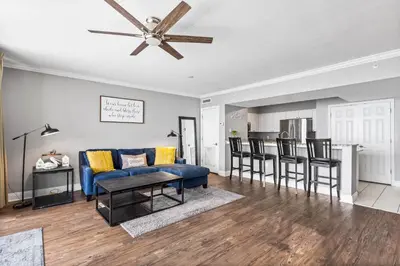 a living room with a blue couch and a table at PCB Emerald beach retreat in Panama City Beach