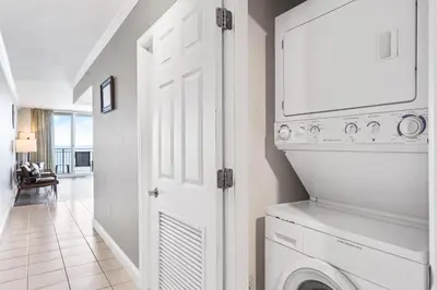 a white laundry room with a washer and dryer at PCB Emerald beach retreat in Panama City Beach