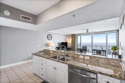 a kitchen with a sink and a view of the ocean at PCB Emerald beach retreat in Panama City Beach