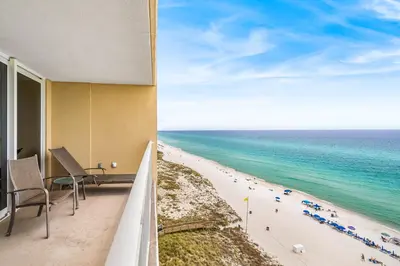a view of the beach from the balcony of a hotel at PCB Emerald beach retreat in Panama City Beach
