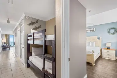 a bedroom with two bunk beds and a hallway at PCB Emerald beach retreat in Panama City Beach