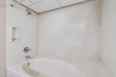 a white bathroom with a tub and a shower at PCB Emerald beach retreat in Panama City Beach