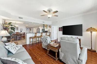 a living room with a couch and a flat screen tv at Treasure Island #1502 in Panama City Beach