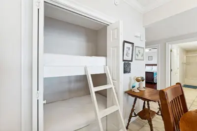 a bedroom with a bunk bed with a ladder and a table at Treasure Island #1502 in Panama City Beach