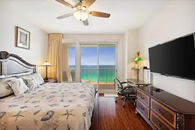 a bedroom with a bed and a flat screen tv at Treasure Island #1502 in Panama City Beach